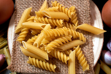 different varieties of pasta on a wooden board. ingredients for italian cuisine