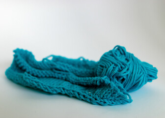 knitting from bright blue yarn without needles with a ball of blue yarn, handicrafts as a pleasure, knitting concept