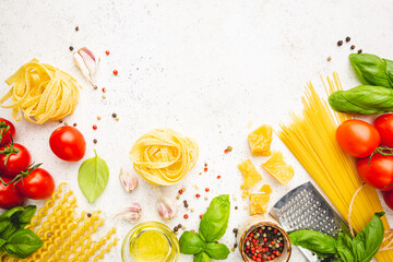 Pasta background. Several types of dry pasta with vegetables and herbs on white background. Free space for text. Top view