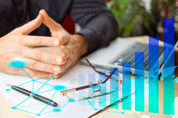 Businessman hands in front of laptop monitor, growth charts and virtual analytics.