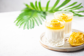 Italian dessert panna cotta with mango in glass on white background