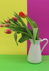 bouquet of red tulips in the white enamel vintage vase 