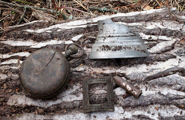 Ancient finds dug up in the ground, a pocket watch, part of a bell, a bullet, a brooch. Searches with a metal detector.