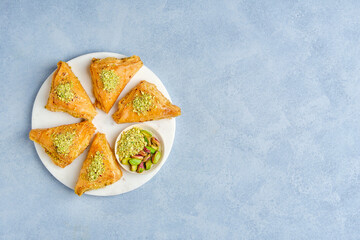 Sweets arabic dessert baklava, warbat, kunafa, kadayif with pistachio and cheese . Top view, copy space