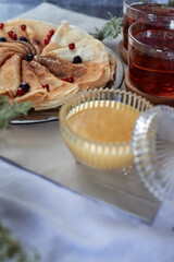 tea with pancakes and honey on the table