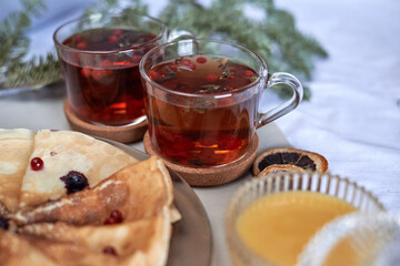 tea with pancakes and honey on the table