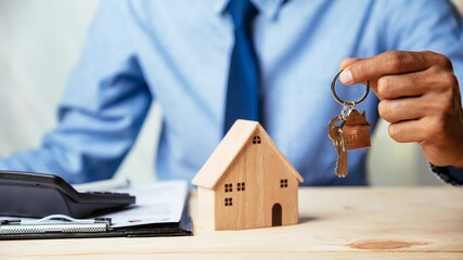 House model with real estate agent and customer discussing for contract to buy house, insurance or...