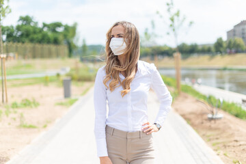 Masked woman walking in a city park