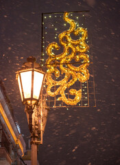 Warm street lamp light with festive christmas decor against the dark night sky