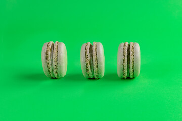 pistachio macarons lined up with green background
