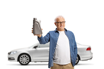 Fototapeta na wymiar Mature man holding a motor oil and standing in front of a silver car
