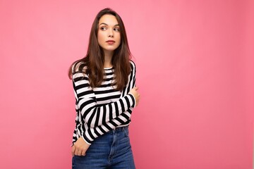 Photo shot of cute attractive pretty young brunette woman wearing casual striped longsleeve isolated over colorful background with copy space