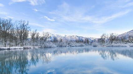 Fototapeta na wymiar Paesaggio con vista sul lago, in inverno, con la neve sulle montagne
