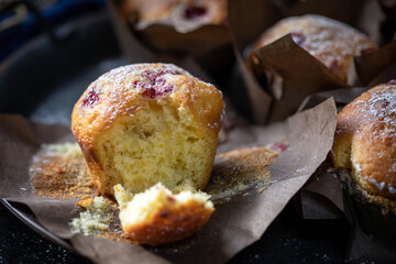 Kefir cupcakes with orange zest and raspberries, powdered with sugar.