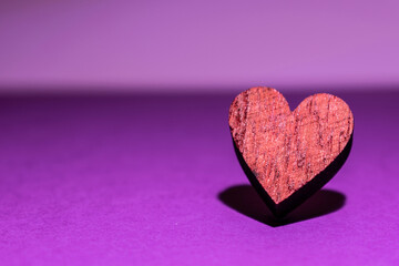 purple background with isolated heart in focus and with its shadow