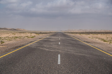 Scenic road in desert. Travel concept. Empty road going behind horizon