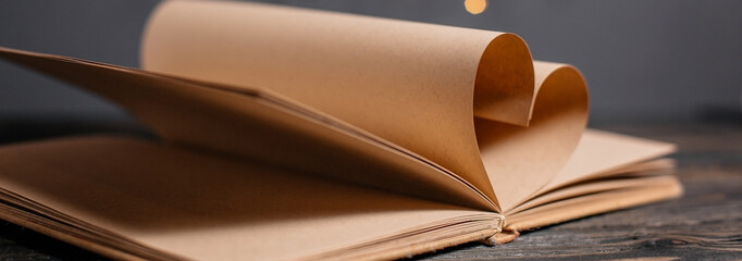 Heart made from book sheets, love and valentine concept on a wooden table