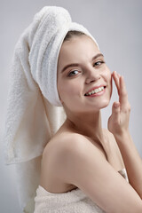 Beautiful girl in towel smiling on white background