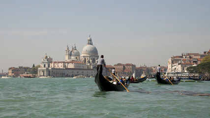 The gondoliers floats on a gondolas with tourists