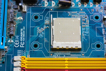 The reverse side of the colorful microboard on a blue background. Electronic board with electrical components, computer equipment.