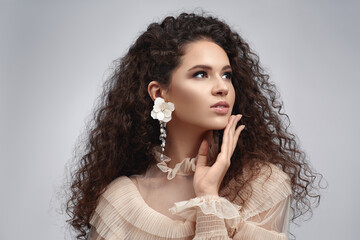 Curly beauty brunette with earrings.