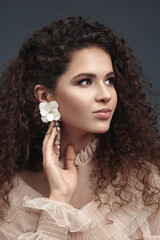 Curly beauty brunette with earrings.