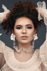 Curly beauty brunette with earrings.