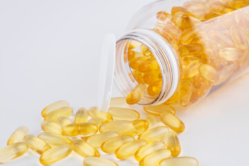 Orange capsules in gel shell transparent bottle rotating white background. Fish oil. Health care. Complex of vitamins. Omega 3, Multivitamins, Antibiotics. Medication, Nutritional supplements. Closeup