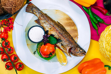 Healthy eating. Cooked fish with vegetables and herbs on a decorated table