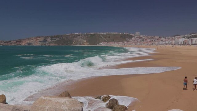 Paisaje de la playa de Nazar&eacute; con las olas rompiendo en la arena