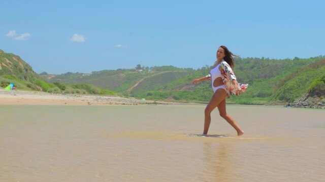mujer joven y atractiva en triquini en el para&iacute;so tropical en Praia do Odeceixe, en Portugal
