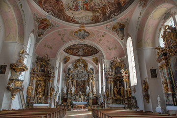 Fototapeta na wymiar Interior architecture with furniture, decorations, frescoes and sculptures of the church of Paul Catholic Parish and St Peter in Oberammergau,