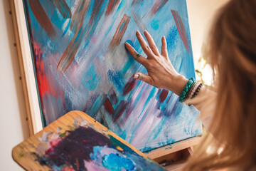 Abstract art paintings. Woman artist painting on canvas by hand and finger