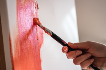 Acrylic painting. Close-up hand with paintbrush paint on canvas