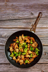 Stir fry with chicken and broccoli on wok. Chinese food.