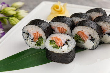  Japanese cuisine. Sushi roll with salmon on grey background.
