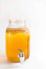 Kombucha-a drink made from tea mushroom in a glass jar with a tap. Transparent mug with a yeast...