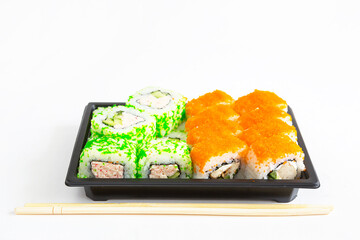 Sushi and rolls in a shipping container. Delivery of Japanese cuisine, set with maki, wasabi and ginger. Fast food to order. White background, copyspace. isolated