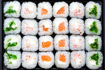 The rolls are laid out in rows, top view, pattern. Background of sushi, Asian cuisine. Delivery