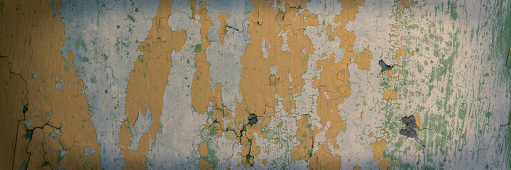 Peeling paint on the wall. Panorama of a concrete wall with old cracked flaking paint. Weathered rough painted surface with patterns of cracks and peeling. Wide panoramic grungy texture for background