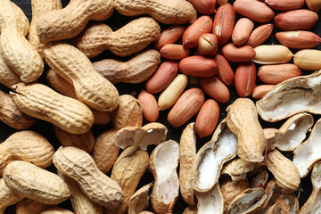 Photograph of a handful of peanuts whole, peeled and empty shells or food background