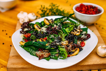salad with meat, mushrooms and sun-dried tomatoes on a decorated table