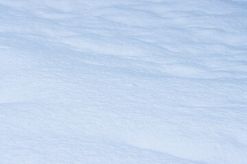 Natural snow texture. Wavy surface of clean fresh snow. Snowy ground. Winter background with a snowdrift. Perfect for Christmas and New Year design. Soft blurred background with shallow depth of field