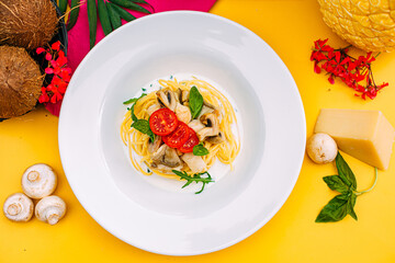 spaghetti with mushrooms and tomatoes in a creamy sauce on a decorated table
