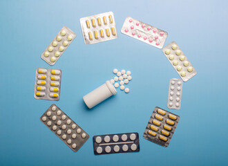 Colored Pills packed in blisters on blue background.