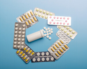 Colored Pills packed in blisters on blue background.