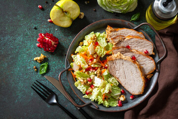 Healthly food. Baked meat steak salad and Chinese cabbage salad with apple, pomegranate, walnuts and on a stone tabletop. Top view flat lay.