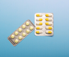 Colored Pills packed in blisters on blue background.