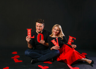 Family keeps the word LOVE love valentine background, Valentine's day design, on the floor hearts married layout. the formula . day, hearts in a red dress girl, barefoot