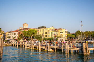 The pier and promenade of Sirmione on Lake Garda. Autumn evening. Lombardy, Italy